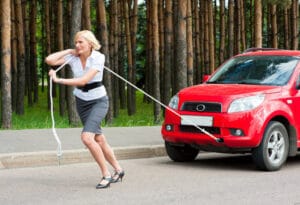 Femme qui tire une voiture avec corde