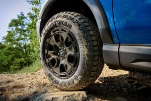 4x4 compact franchissant un obstacle rocheux en pleine nature, démontrant ses capacités tout-terrain malgré sa taille réduite.