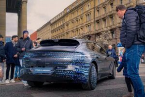 Denza 9 GT photographiée de dos dans une rue européenne, montrant son design élégant avec ses feux arrière LED distinctifs qui s