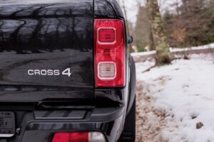 4x4 abordable traversant une zone boueuse, coffre ouvert montrant sa grande capacité de chargement